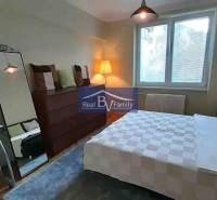 Ložnice v 2-pokojovém bytě s velkým zrcadlem a podlahou s dřevěným dekorem.