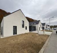 Rodinný dům na ulici Pod Drieňovou v Kamenici nad Cirochou, řadová zástavba s auty.