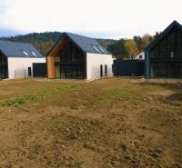 Rodinné domy na ulici Pod Drieňovou v Kamenici nad Cirochou, obklopené přírodou a zelení.