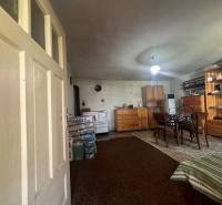 Interiér s dřevěným nábytkem, kobercem, stolem a chata dodává rustikální atmosféru.