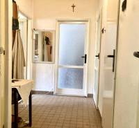 Chodba v 3-pokojovém bytě s dlažbou, zrcadlem a plátěným stolem.