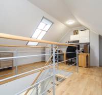 Podkrovní pracovní prostor s podlahou s dřevěným dekorem ve 4-pokojovém bytě.