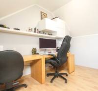 Pracovna ve 4-pokojovém bytě s počítačem, kancelářskou židlí a podlahou s dřevěným dekorem.