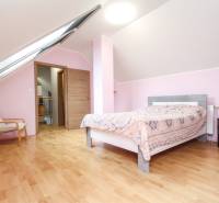 Podkrovní ložnice ve 4pokojovém bytě s podlahou s dřevěným dekorem.