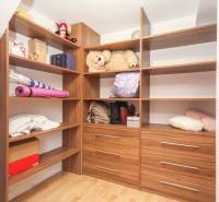 Úložný prostor s policemi a zásuvkami ve 4-pokojovém bytě, podlaha s dřevěným dekorem.