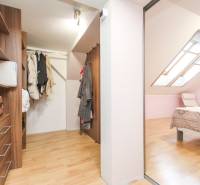 Šatna a ložnice ve 4pokojovém bytě s podlahou s dřevěným dekorem.