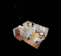 Pohled do 1-pokojového bytu s podlahou s dřevěným dekorem a slunným obývacím prostorem.