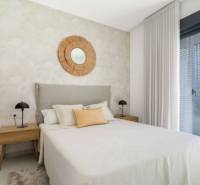 Ložnice v rekreačním apartmánu, postel, noční stolky, velké okno.