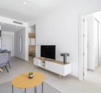 Rekreační apartmán s otevřeným obývacím pokojem, jídelním stolem a podlahou s dřevěným dekorem.