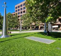 Zeleň a kovové sochy před budovou v Bratislavě - Ružinově na ulici Košická, 3-pokojový byt.