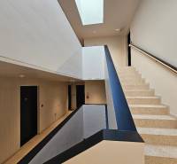 Schodiště s terazzovými schody a světlým stropem ve 3-pokojovém bytě.