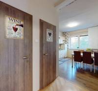 Vstupní hala 2pokojového bytu s podlahou s dřevěným dekorem a jídelním koutem.