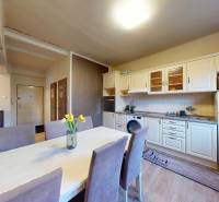 Kuchyně a jídelní kout v 2-pokojovém bytě s podlahou s dřevěným dekorem.