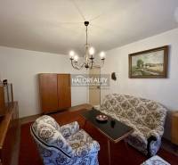 Obývací pokoj ve 4pokojovém bytě s klasickým nábytkem a elegantním lustrem.