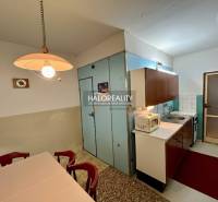 Kuchyně ve 4-pokojovém bytě s jídelním stolem a kuchyňskou linkou.