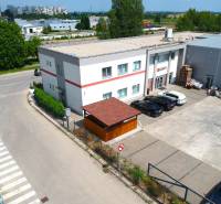 Obchodní prostory na Strojárenské ulici v Trnavě, s parkovištěm a okolní zástavbou.