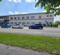 Obchodní prostory na Strojárenské ulici v Trnavě, s parkováním a cyklistou.