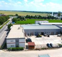 Obchodní prostory na Strojárenské ulici v Trnavě s přilehlým parkovištěm a zelení v okolí.