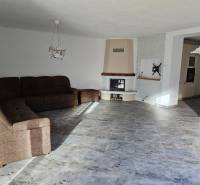 Obývací pokoj v rodinném domě s podlahou s dřevěným dekorem a rohovou pohovkou.