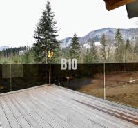 Chata v Terchové s terasou nabízí výhled na zasněžené hory a les.