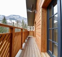 Balkon chaty v Terchové s výhledem na zasněžené hory a lesy.