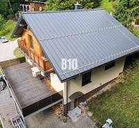 Chata v Terchové se šikmou střechou, velkou terasou a dřevěnými detaily.