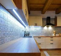 Kuchyně v chatě s dlaždicemi a podlahou s dřevěným dekorem, osvětlená LED světly.