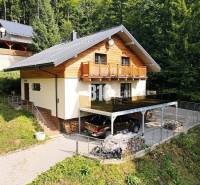 Chata v Terchové obklopená lesem s parkovací plochou a terasou.