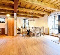 Otevřený interiér v chatě s podlahou s dřevěným dekorem a jídelním stolem.