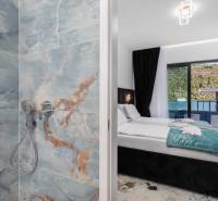 Koupelna s mramorovými obklady a ložnice ve vile s výhledem na moře.