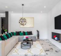 Obývací pokoj s pohodlnou sedačkou, krbem a dekoracemi ve vile.