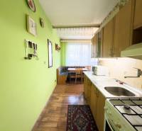Kuchyně ve 3-pokojovém bytě s podlahou s dřevěným dekorem a zelenými stěnami.