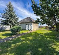 Rodinný dům v Ondrejovcích obklopený zeleným trávníkem a stromy v prostorné zahradě.