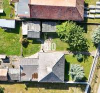 Rodinný dům v Ondřejovcích s přístavbami, zahradou a přilehlou cestou.