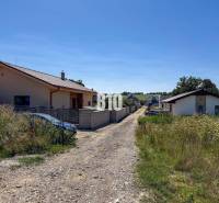 Rodinné domy u cesty obklopené trávou v Čeľadiciach, Pozemky - bydlení.