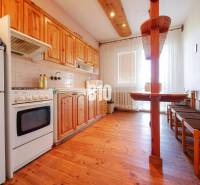 Kuchyně v rodinném domě s dřevěným dekorem a jídelním koutem.