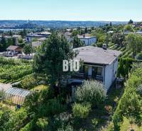 Pohled na rodinný dům na ulici Kamenná v Nitře obklopený zelení a městskou panorámou.