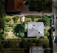 Rodinný dům na Kamenné ulici v Nitře, obklopený zelení a ovocnými stromy.