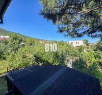 Zahrada u rodinného domu na Kamenné ulici v Nitře s výhledem na les.