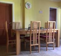 Jídelna v rodinném domě se židlemi a stolem na podlaze s dřevěným dekorem.