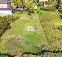 Pozemky - bydlení v Nitře s upravenou zahradou a okolními domy.