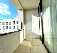 Balkon 2-pokojového bytu na Karpatské ulici v Popradu s výhledem na nižší budovu.