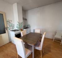 Jídelna v rodinném domě s plynovým sporákem a podlahou s dřevěným dekorem.