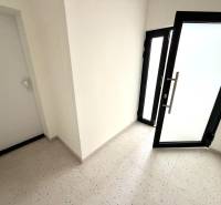 Vstupní chodba v 2-pokojovém bytě se skleněnými dveřmi.