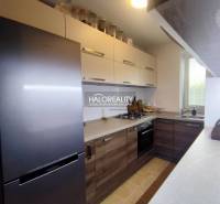 Kuchyně v 3-pokojovém bytě s podlahou s dřevěným dekorem a moderními spotřebiči.