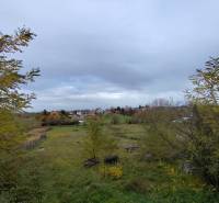 Pozemek ve městě Velký Bab, určený k bydlení, obklopený zelenými porosty a venkovskou krajinou.