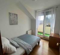 Světlý pokoj s postelí ve 3-pokojovém bytě, nástěnná dekorace s abecedou.