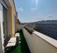 Balkon 3pokojového bytu s výhledem na panoráma města, se zelení a posezením.