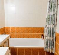 Koupelna s vanou a keramickými obklady v 2pokojovém bytě.