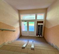 Vstupní chodba bytového domu na Hviezdoslavově ulici v Senici se schodištěm.